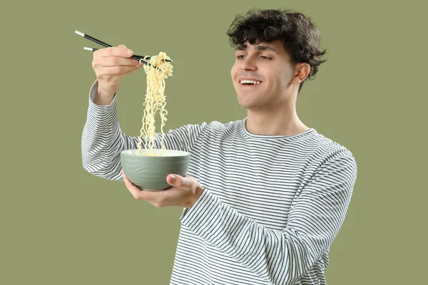Ung Man Äter Välsmakande Kinesisk Mat Grön Bakgrund — Stockfoto