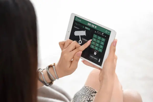 stock image Young woman using smart home security system control panel, closeup