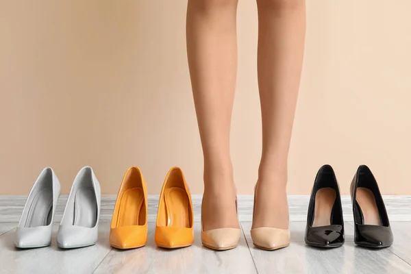 stock image Female legs with different stylish shoes against color wall, closeup