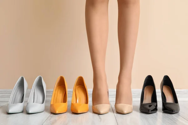 Stock image Female legs with different stylish shoes against color wall, closeup