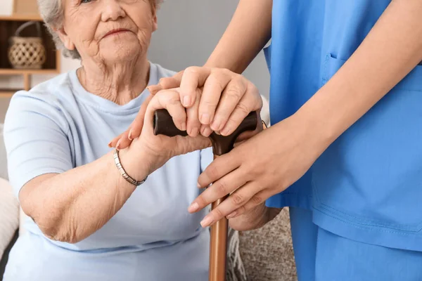 在家里拿着手杖和女护理人员的老年妇女 特写镜头 — 图库照片