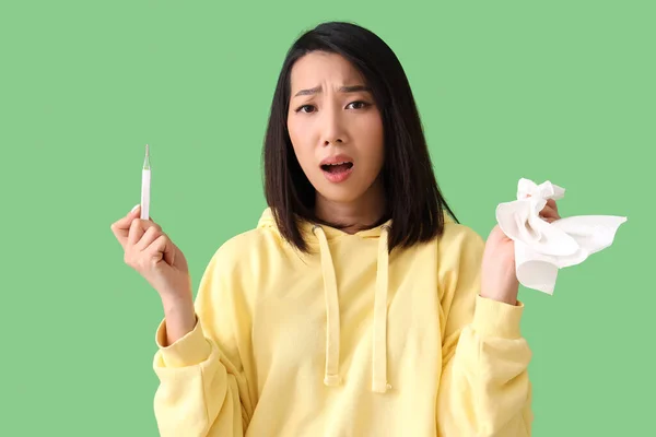 Kranke Asiatin Mit Gewebe Und Thermometer Auf Grünem Hintergrund — Stockfoto