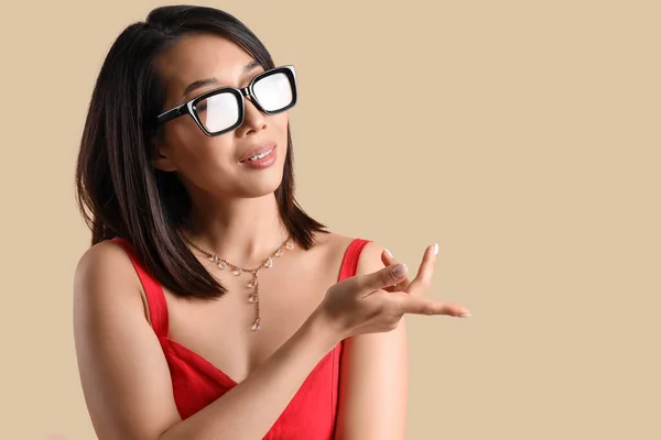 Mulher Asiática Bonita Óculos Elegantes Apontando Para Algo Fundo Bege — Fotografia de Stock