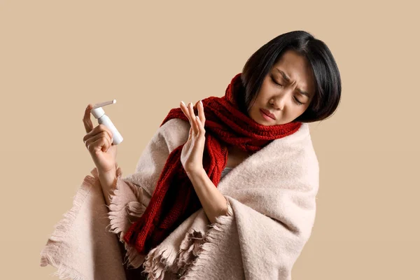 Kranke Asiatin Lehnt Spray Gegen Halsschmerzen Auf Beigem Hintergrund — Stockfoto