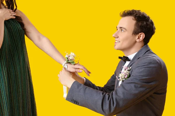 Beautiful Prom Couple Tying Corsage Yellow Background — Stock Photo, Image