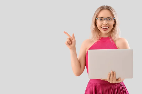Young Woman Stylish Eyeglasses Laptop Pointing Something Light Background — Stock Photo, Image