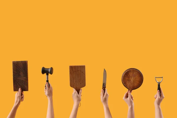 Kadın Eli Kesme Tahtası Sarı Arka Planda Farklı Mutfak Aletleri — Stok fotoğraf