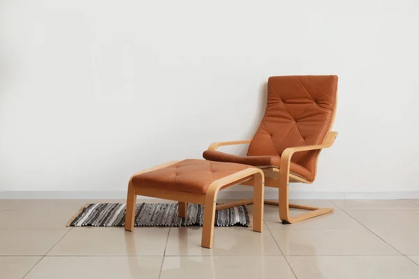 靠墙的舒适的棕色扶手椅 脚凳和时髦的地毯 — 图库照片