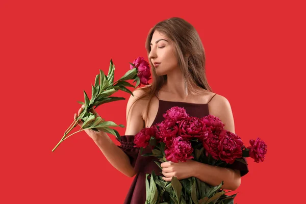 Kırmızı Arka Planda Şakayık Çiçekleri Olan Güzel Bir Kadın — Stok fotoğraf