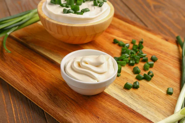 Bowls Tasty Sour Cream Sliced Green Onion Wooden Background — Stock Photo, Image
