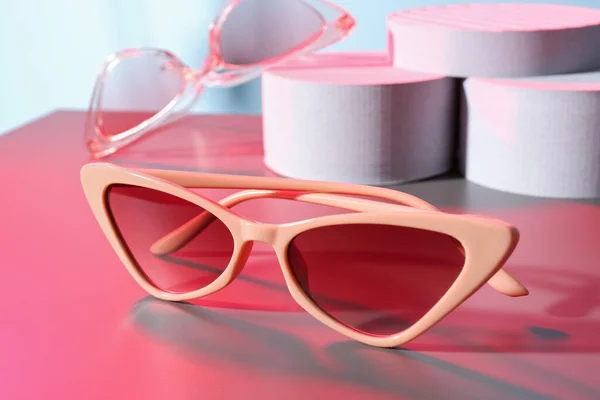 Podiums Różnych Stylowych Okularów Przeciwsłonecznych Kolorowym Tle — Zdjęcie stockowe