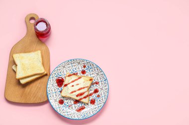 Pembe arka planda tost ve reçel dolu tabak.