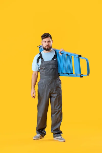 Male Worker Ladder Yellow Background — Fotografia de Stock