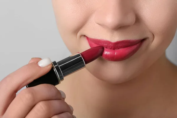 Woman Applying Red Lipstick Grey Background Closeup — Stock Photo, Image
