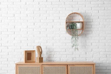 Dekorlu ve raflı modern çekmeceler. Odadaki tuğladan duvarda asılı.