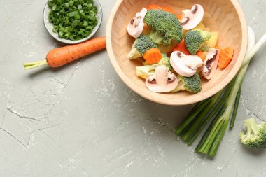 Gri arka planda taze sebzeli kase