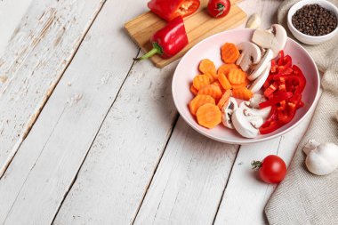 Hafif ahşap arka planda taze sebzeli kase