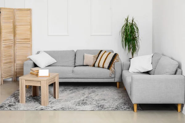 居心地の良いグレーのソファと木製のコーヒーテーブル付きのリビングルームのインテリア — ストック写真