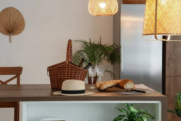 ウィッカーバスケット 光るランプ付きのモダンなキッチンの木製の島のテーブルの上の新鮮なパン — ストック写真