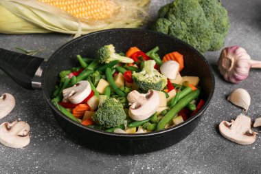 Gri arka planda taze sebzeli tava.