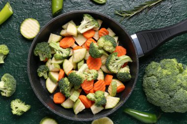 Yeşil arka planda taze sebzeli kızartma tavası