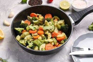 Gri arka planda lezzetli sebzeli kızartma tavası