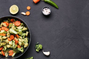 Siyah arka planda lezzetli sebzeli kızartma tavası