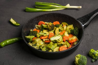 Siyah arka planda lezzetli sebzeli kızartma tavası