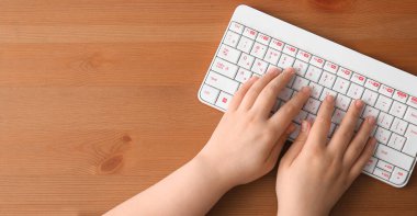 Programcının elleri ve ahşap zemin üzerinde PC klavyesi metin ve üst görünüm için boşluk