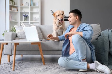 Evinde Labrador köpeği olan genç bir adam.