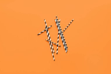 Turuncu arka planda farklı kağıt içme çubukları