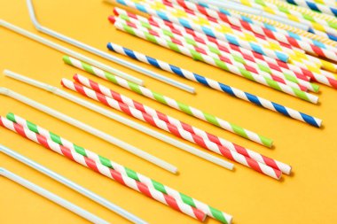 Turuncu arka planda farklı içki pipetleri