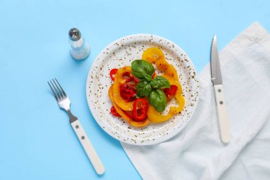 Mavi arka planda lezzetli ızgara dolmalık biber dilimleri ile tabak.