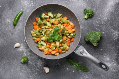 Arka planda farklı sebzelerle kızartma tavası.