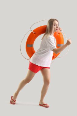 Yüzük şamandırası açık arka planda çalışan kadın cankurtaran.