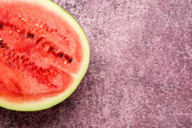 Mor arka planda taze karpuzun yarısı.