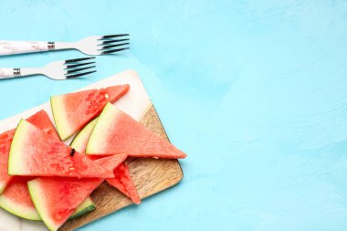 Mavi arka planda taze karpuz parçaları olan tahta