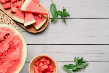 Gri ahşap arka planda taze karpuz parçaları ile yemek ve kâse.