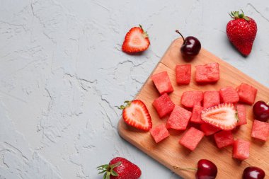 Taze karpuz parçaları ve mavi arka planda farklı böğürtlenler.