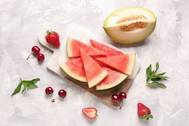 Taze karpuz parçaları ve beyaz arka planda farklı böğürtlenler olan tahta.