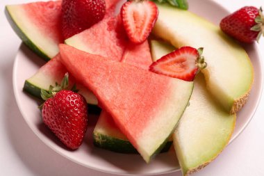 Taze karpuz parçaları ve farklı arkaplanda farklı böğürtlenler.