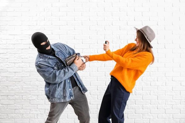 Young Woman Pepper Spray Defending Herself Thief White Brick Background — Stockfoto