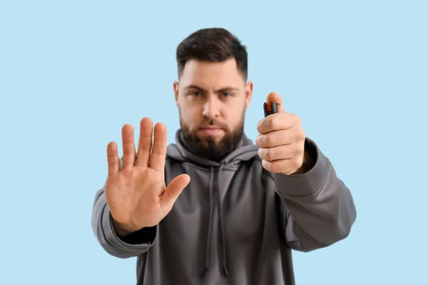 Young Man Pepper Spray Self Defence Blue Background Closeup — 스톡 사진