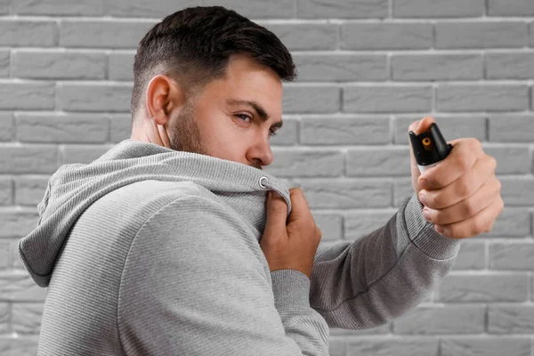 Young Man Pepper Spray Self Defence Grey Brick Background Closeup — Fotografia de Stock