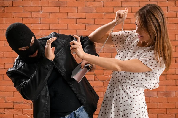 Young Woman Pepper Spray Defending Herself Thief Brick Background — Stockfoto