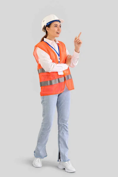 Vrouwelijke Werkster Vest Wijst Naar Iets Een Lichte Achtergrond — Stockfoto