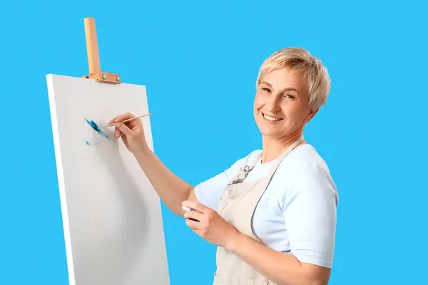 Volwassen Vrouwelijke Kunstenaar Schilderij Beeld Blauwe Achtergrond — Stockfoto