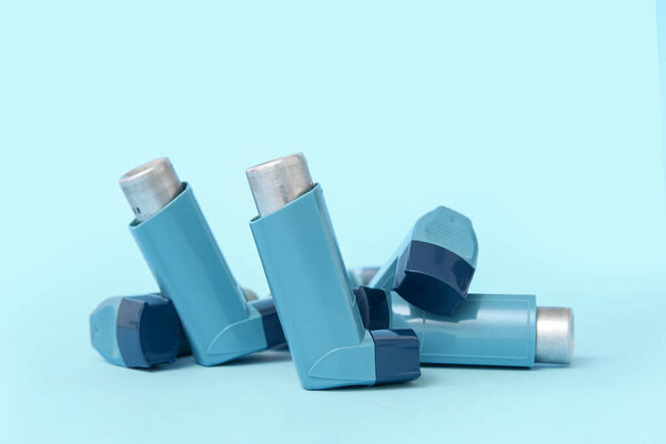 Asthma inhalers on blue background