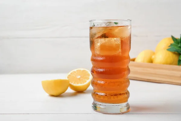 白木の背景にレモン入りの氷茶と箱のガラス — ストック写真