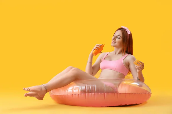 Young Woman Sunscreen Cream Inflatable Ring Yellow Background — Stock Photo, Image